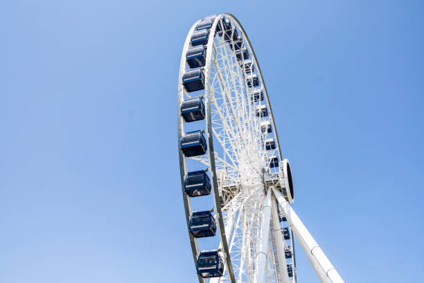 istock White and Black Ferris wheel in from of blue sky with clouds 1426002811