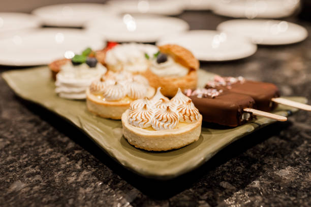 Catering. Beautifully decorated sweets on the table and fruit. Delicious wedding reception candy bar dessert table full with cakes and sweets