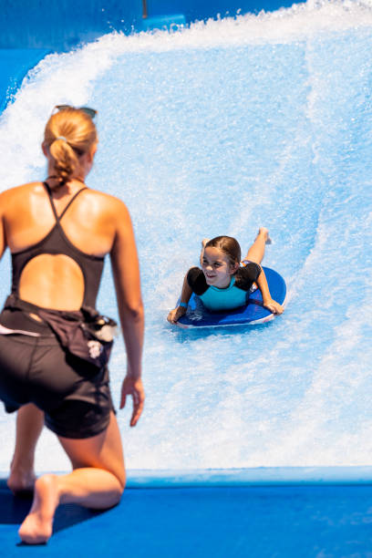 istock Mother watches young boy descend waterslide 1426004666