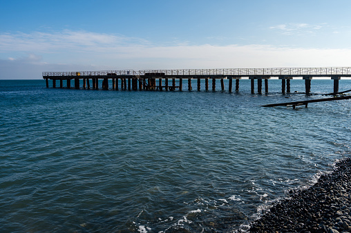 Pier on the sea coast on a sunny day against a blue sky