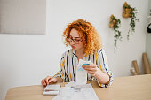 Shot of a young woman looking stressed out while calculating home  finances at home office