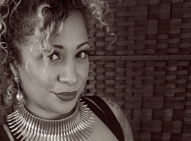 Beautiful woman wearing a bold gold necklace with a low-cut black cocktail dress