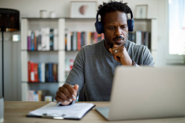 istock Man with bluetooth headphones working at home 1426011927