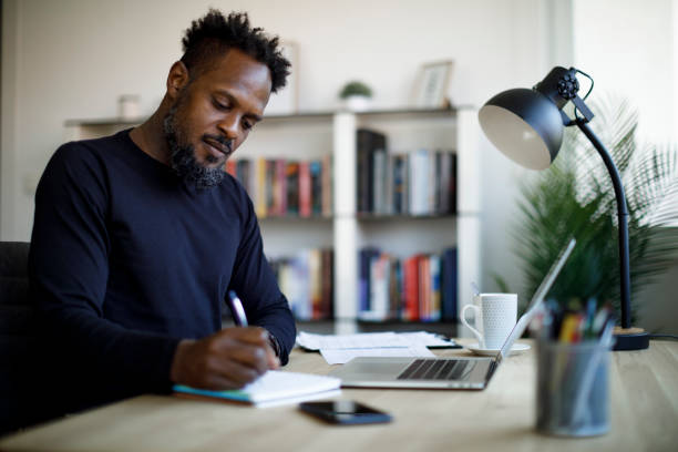 Adult male student studying at home stock photo