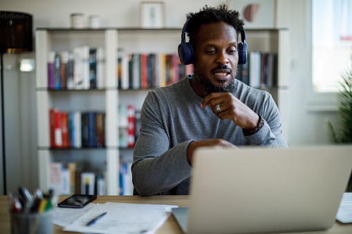 Hombre con auriculares asiste a un curso en línea en casa photo