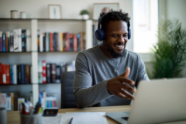 istock Smiling man with headphones attends an online course at home 1426011991