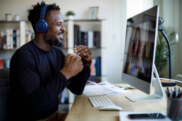 istock Smiling man with headphones having video call at home office 1426012000