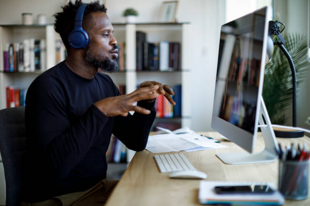 istock Man with headphones having video call at home office 1426012014