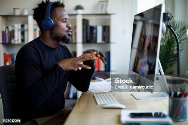 Man With Headphones Having Video Call At Home Office Stock Photo - Download Image Now