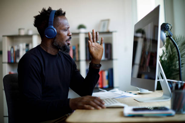 istock Man with headphones having video call at home office 1426012060