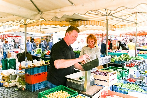 Fruit and greengrocer couple at their stall at a farmers market in Germany. This image is part of a series.