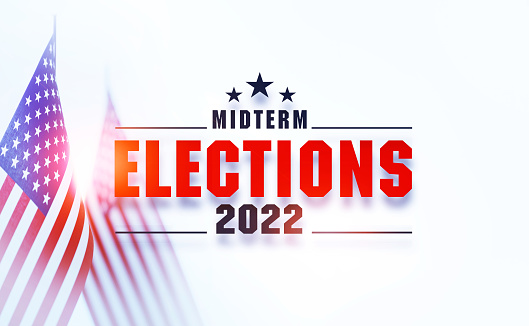 Midterm Elections 2022 message written over American flag pair with selective focus. Horizontal composition with copy space. Front view.