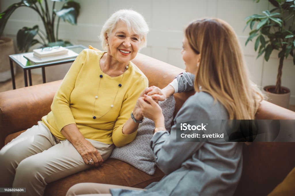 Senior woman talking with daughter Senior woman talking with her daughter at home. Daughter Stock Photo