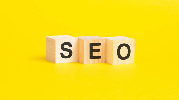 istock wooden blocks with text SEO on yellow background. business concept 1426025621