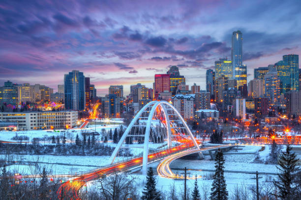 Light trails from rush hour traffic light up Walterdale Bridge in Edmonton, Canada, on a sunset winter night Light trails from rush hour traffic light up Edmonton downtown Winter sunset skyline showing Walterdale Bridge across the frozen, snow-covered Saskatchewan River and surrounding skyscrapers. alberta stock pictures, royalty-free photos & images