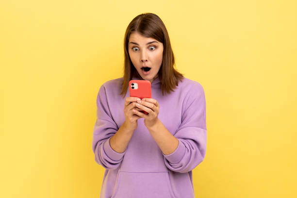 istock Excited woman reading message on smartphone using mobile device for communication surprised with app 1426026550