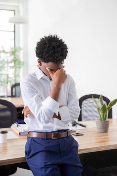istock Tired male office worker rubbing forehead 1426026776