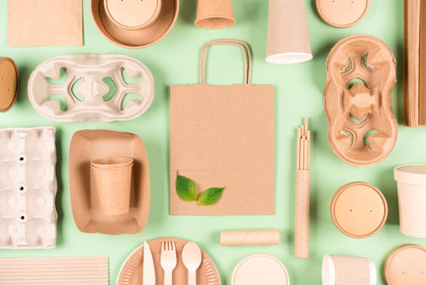 istock Flat lay style composition made with eco tableware bundle, paper utensils, paper bag and holders, wooden cutlery set over light green background. Sustainable food packaging concept 1426030094