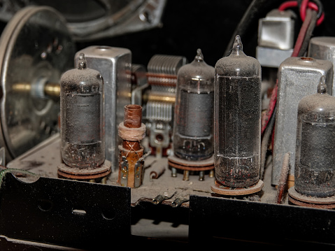 Inside view of the antique dusty components of1958 tube radio.