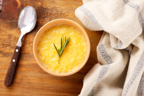 Polenta in ceramic bowl on rustic wooden table. Cream of corn or mamaliga Polenta in ceramic bowl on rustic wooden table. Cream of corn or mamaliga.Top view mamaliga stock pictures, royalty-free photos & images
