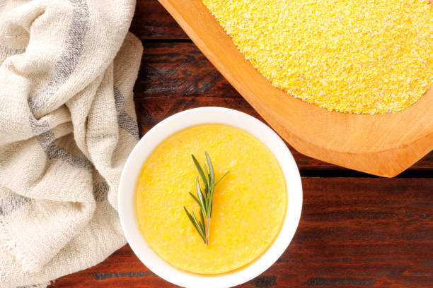 Polenta in ceramic bowl on rustic wooden table. Cream of corn or mamaliga Polenta in ceramic bowl on rustic wooden table. Cream of corn or mamaliga.Top view mamaliga stock pictures, royalty-free photos & images