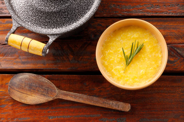 Polenta in ceramic bowl on rustic wooden table. Cream of corn or mamaliga Polenta in ceramic bowl on rustic wooden table. Cream of corn or mamaliga.Top view mamaliga stock pictures, royalty-free photos & images