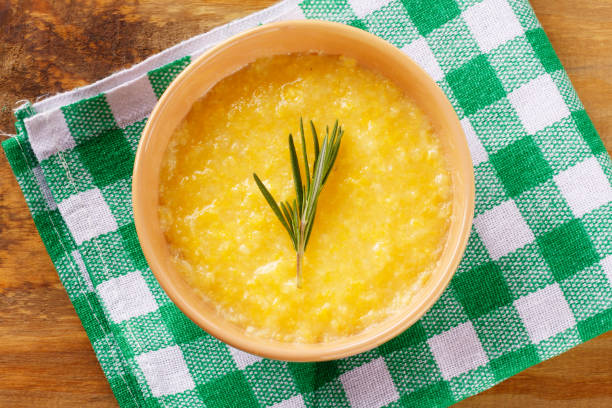 Polenta in ceramic bowl on rustic wooden table. Cream of corn or mamaliga Polenta in ceramic bowl on rustic wooden table. Cream of corn or mamaliga.Top view mamaliga stock pictures, royalty-free photos & images