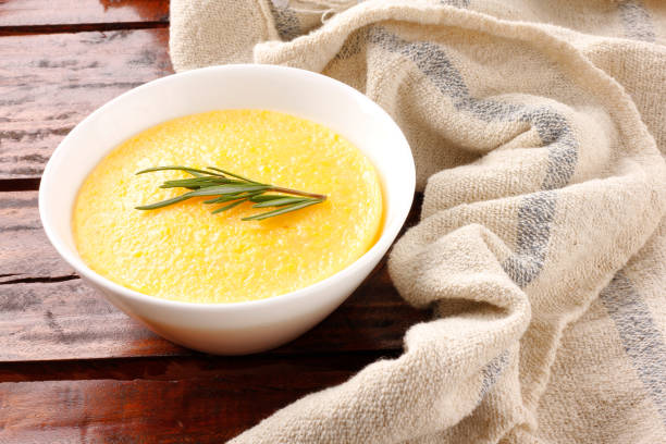 Polenta in ceramic bowl on rustic wooden table. Cream of corn or mamaliga Polenta in ceramic bowl on rustic wooden table. Cream of corn or mamaliga.Top view mamaliga stock pictures, royalty-free photos & images