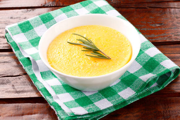 Polenta in ceramic bowl on rustic wooden table. Cream of corn or mamaliga Polenta in ceramic bowl on rustic wooden table. Cream of corn or mamaliga.Top view mamaliga stock pictures, royalty-free photos & images