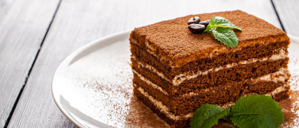 istock Tiramisu dessert decorated with mint on white plate. 1426049976