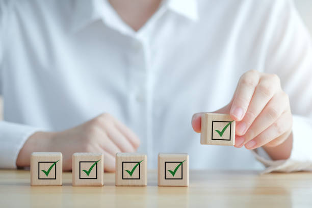 istock Checklist, Task list, Survey and assessment, Quality Control, Goals achievement and business success. Elections and Voting, Vote, to do list, Hand holding green check mark on wooden block. 1426052267