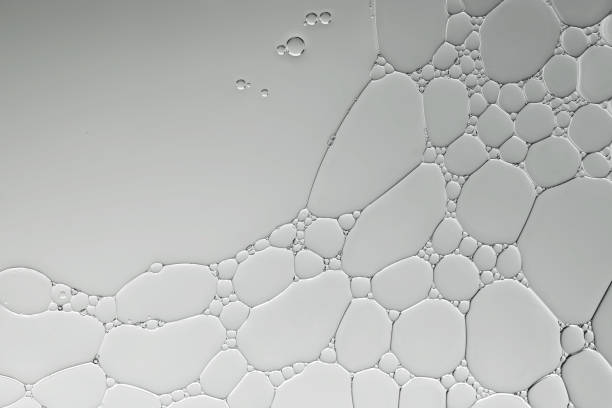 istock Art image of oil and water bubbles to create interesting pattern and shapes on gradient grey-silver background. 1426054903