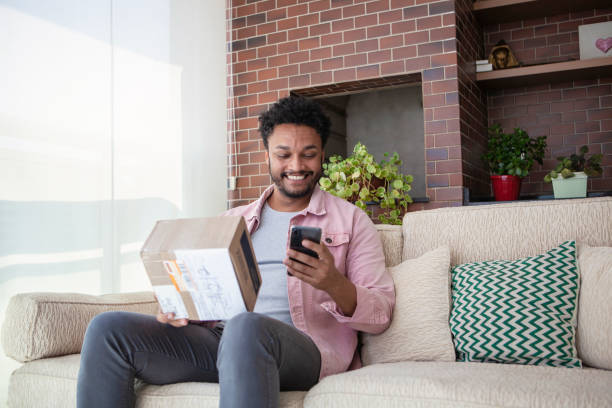 African American young man shopping online at home African American young man shopping online at home home shopping stock pictures, royalty-free photos & images