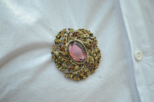 Closeup portrait of brooch with isolated white clothes background