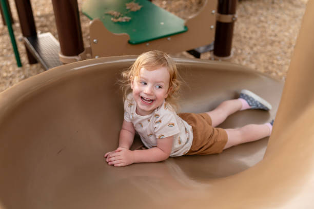 istock Joyful Toddler Going Down Slide at the Park 1426078601