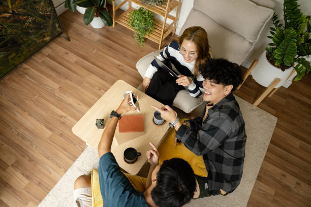 istock Groups of friends enjoy using various technologies. in their living room. 1426093573
