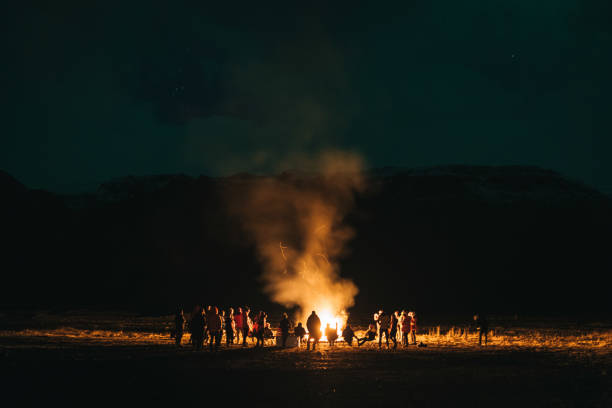 Night camp in the forest with a campfire. A tent with a fire and a chair in the evening in the forest. Outdoor recreation