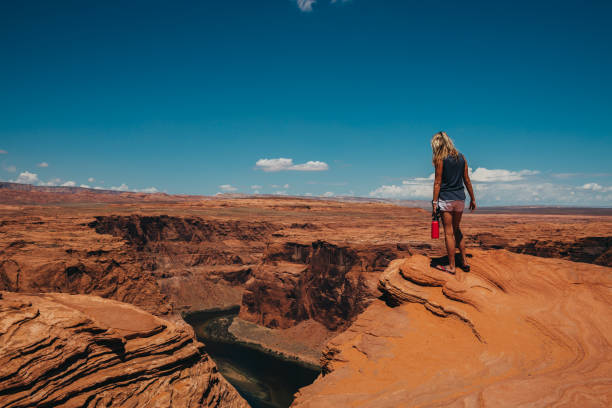 istock Woman walks along canyon ridge above river 1426104177