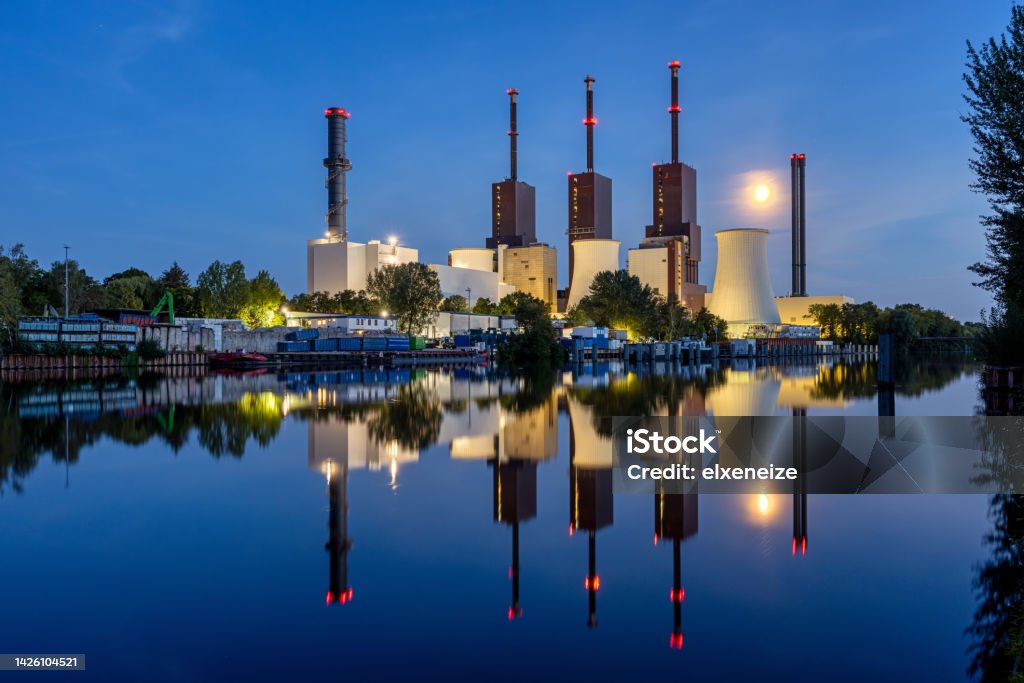 A power station in Berlin at night A power station in Berlin at night with a perfect reflection in the water Air Pollution Stock Photo