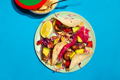 Vegan mushroom tacos with pickled red onions and cabbage, served with slice of lime