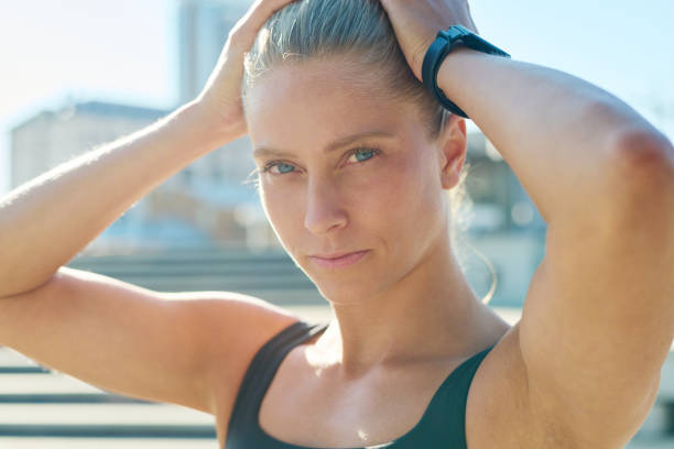 istock Young serious blond sportswoman looking at camera while keeping hands on head 1426108198