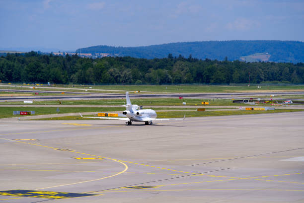 корпорат�ивный самолет, вылетающий из международного аэропорта швейцарии. - falcon стоковые фото и изображения