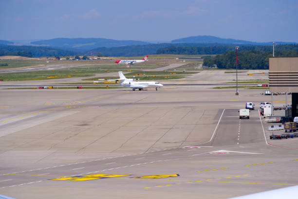 корпоративный самолет, вылетающий из международного аэропорта швейцарии. - falcon стоковые фото и изображения