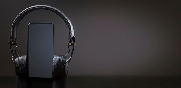 black headphones on smartphone music online concept, mockup