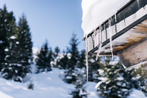 A snow covered luxury home under blue sky.