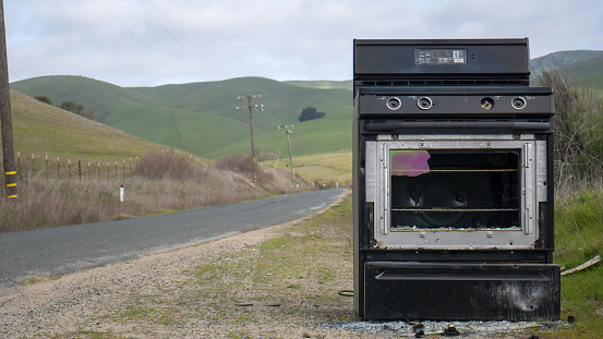Broken stove oven on the side of the road