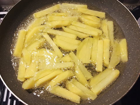 French fries, frying potatoes in cooking oil in a frying pan