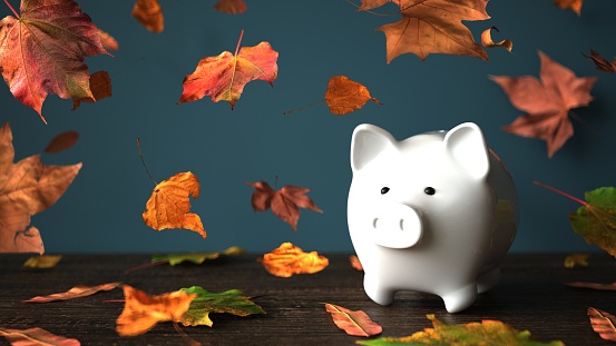 Piggy bank in autumn leaves. 3d illustration.
