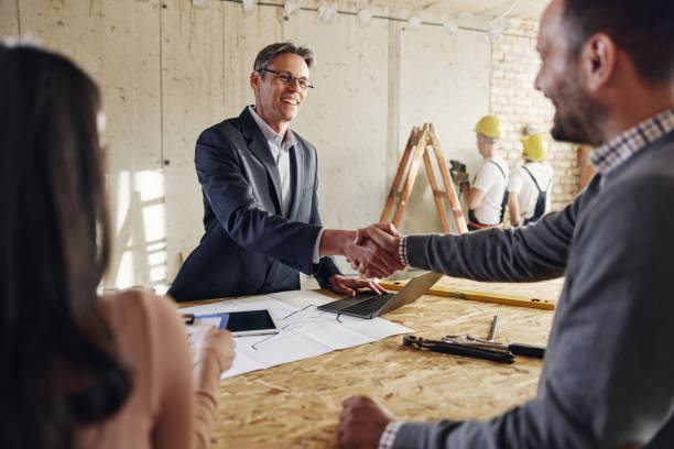 istock Happy agent came to an agreement with a couple at construction site. 1426135686