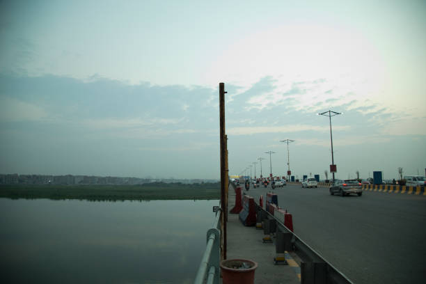 istock Road traffic and lake against cloudy sky 1426137531